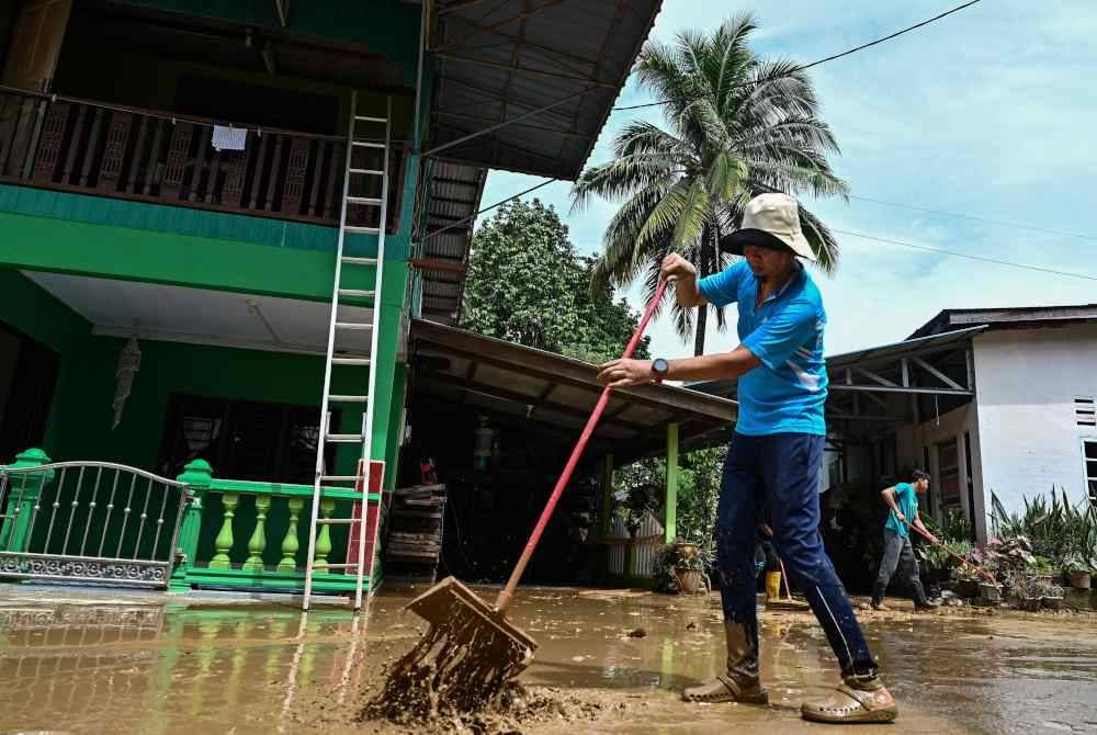 Penduduk mula membersihkan lumpur di kediaman masing-masing setelah banjir mulai surut - Gambar hiasan Bernama