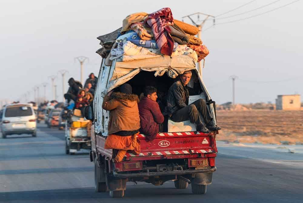 Penduduk Syria terpaksa pindah beramai-ramai setelah perkampungan mereka di Aleppo ditawan puak pemberontak. - Foto Agensi