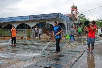 Kira-kira 30 ahli qariah Masjid Pasir Simpul, Hulu Terengganu berganding bahu membanting tulang membersihkan pelbagai peralatan masjid kampung itu seperti karpet yang turut terkesan banjir. Foto Bernama