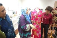 Nicole melihat baju batik elemen bunga lado di pameran sempena Hari Batik Malaysia.