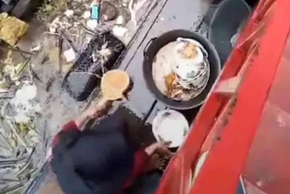 Video viral seorang wanita mencuci pinggan mangkuk bersebelahan sungai dicemari sampah sarap di sebuah restoran di Palembang. - Agensi