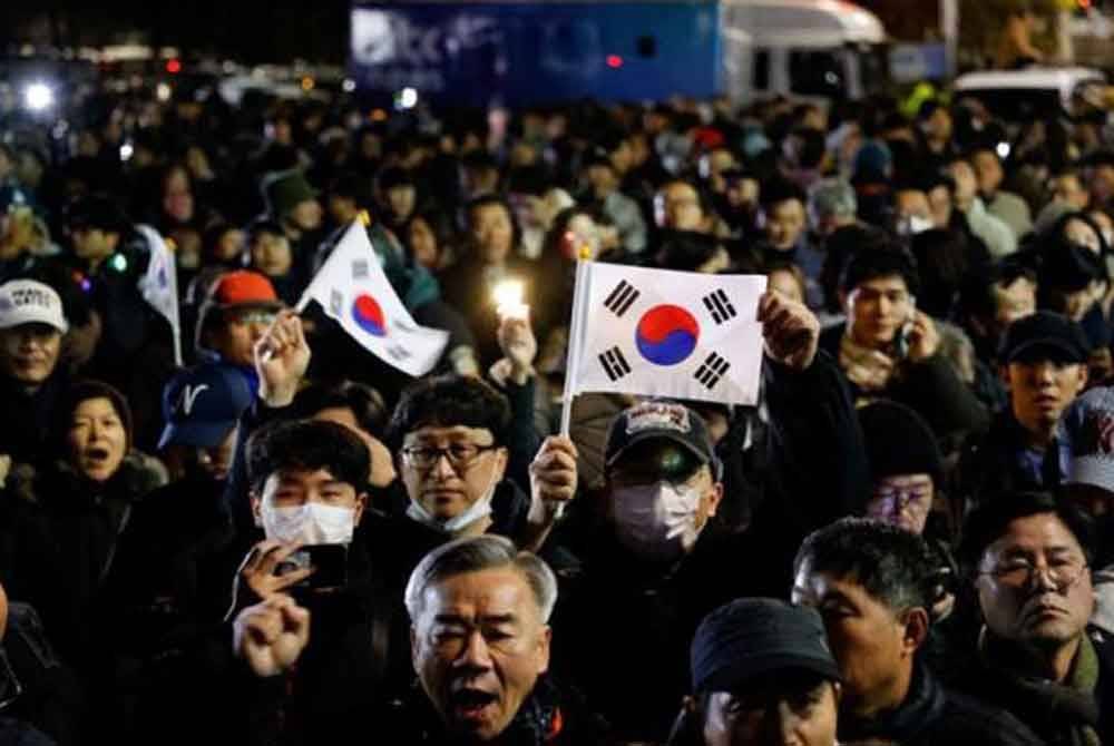 Orang ramai berkumpul di luar Perhimpunan Kebangsaan di Seoul pada awal pagi 4 Disember selepas Presiden Korea Selatan, Yoon Suk Yeol mengisytiharkan undang-undang tentera. Foto Reuters