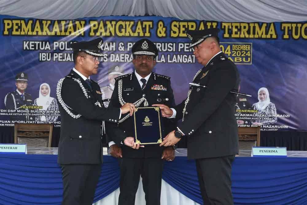 Akmalrizal (kanan) dilantik sebagai Ketua Polis Daerah Kuala Langat baharu dengan disaksikan Hussein (tengah).