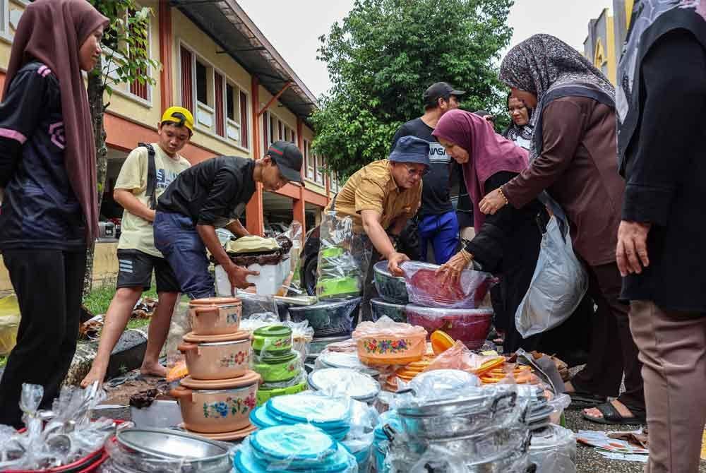 Orang ramai membeli barang lelong yang dijual oleh peniaga di Zon Bebas Cukai Rantau Panjang hari ini. Foto Bernama