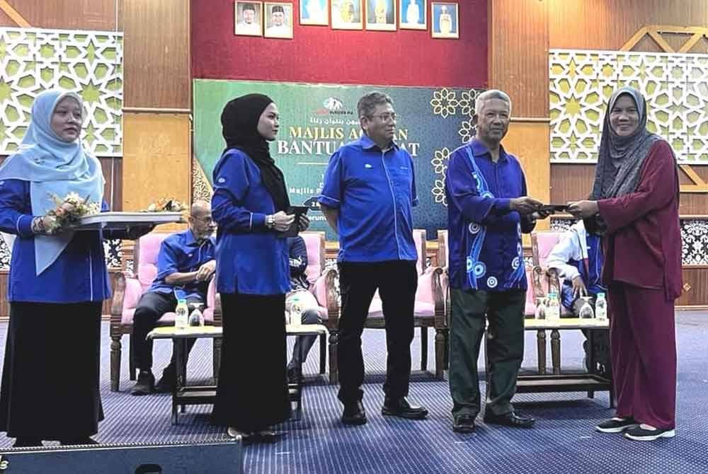 Pengerusi Jasa Merin Malaysia Sdb Bhd, Datuk Mokhtar Nong (dua dari kanan) menyerahkan bantuan zakat sempena majlis agihan zakat di Kemaman, baru-baru ini.