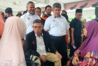 Saifuddin Nasution (duduk dua kiri) semasa turun melawat mangsa banjir di PPS Sekolah Kebangsaan Bukit Tinggi dekat Jitra pada Rabu.