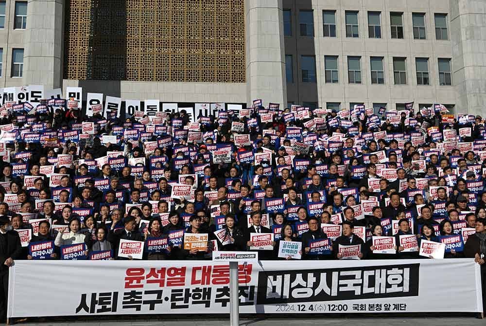 Ahli-ahli parti pembangkang utama Korea Selatan dan pengamal undang-undang memegang sepanduk bertulis "Yoon Suk Yeol patut letak jawatan!" semasa perhimpunan menentang Suk Yeol di Perhimpunan Kebangsaan di Seoul