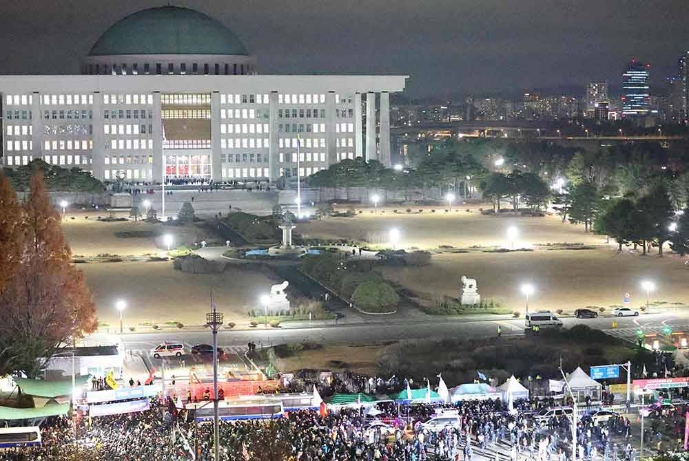 Orang ramai berkumpul di luar Bangunan Perhimpunan Kebangsaan di Seoul. Foto AFP