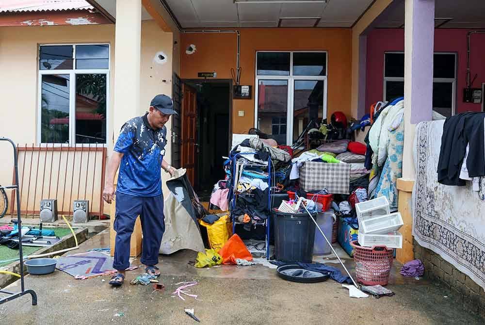 Penduduk mula membersihkan rumah selepas kawasan perumahan itu dilanda banjir berikutan hujan lebat semasa tinjauan di Taman Desa Tanjung Damai, hari ini. Foto Bernama