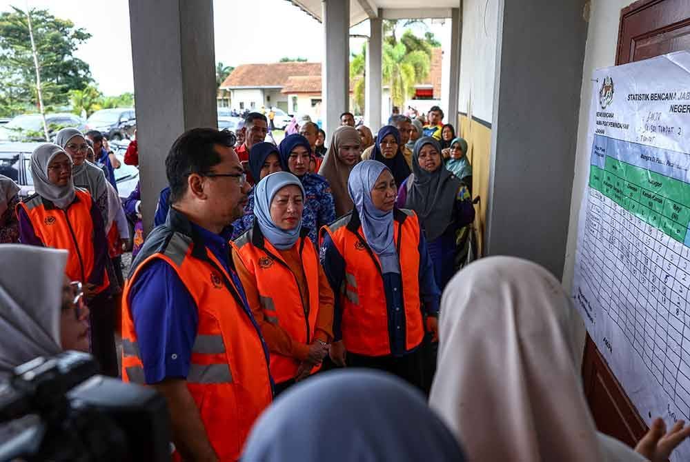 Nancy mendengar taklimat berkenaan status jumlah mangsa yang ditempatkan di Pusat Pemindahan Sementara (PPS) Sekolah Kebangsaan Seri Tumpat 2 pada Khamis. Foto Bernama