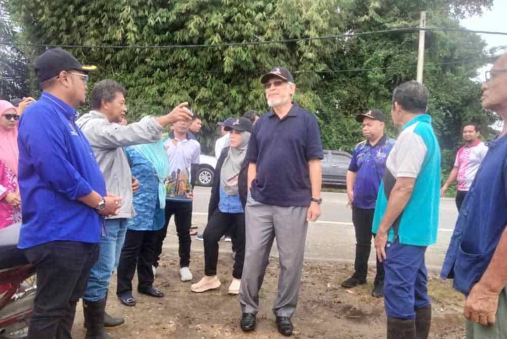 Khalid (tengah) mendengar luahan pesawah yang terjejas banjir.