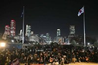 Orang ramai berkumpul di pekarangan Perhimpunan Kebangsaan di Seoul pada 4 Disember. Foto AFP