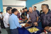 Armizan (tengah) menyantuni beberapa calon SPM ketika makan tengah hari di SMK Air Jernih di Kemaman.