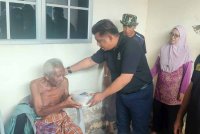 Azizul (dua dari kiri) semasa menyertai misi bantuan pasca banjir Majlis Belia Negeri Kedah bersama badan bukan kerajaan di Kampung pasir, Kepala Batas, dekat Jitra pada Khamis.