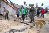 Mohd Nassuruddin (dua dari kanan) melihat jalan yang runtuh kerana arus deras banjir di Tumpat.