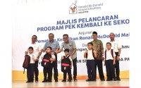 Dua dari kiri: Pengurus Besar RMHC Malaysia, Nasri Nordin dan Presiden RMHC Malaysia, Datuk Azmir Jaafar menyampaikan sumbangan Pek Kembali ke Sekolah kepada murid- murid dari daerah Tampin.