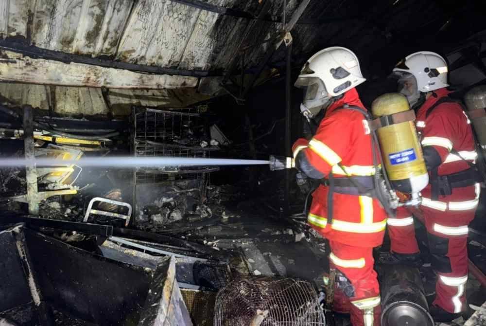 Anggota bomba memadamkan api dalam kejadian kebakaran di sebuah kedai perkakasan di Jalan Pasir Puteh,Kampung Chi Cha Kubang Kerian.