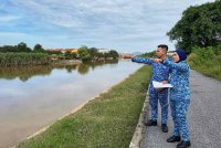 Muhammad Suhaimi meninjau paras air di Alor Kanchut di sini, susulan amaran hujan berterusan yang dikeluarkan oleh MetMalaysia bermula Ahad.