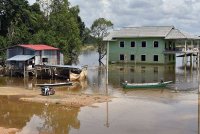 Penduduk setempat menggunakan bot untuk melakukan kegiatan harian berikutan kawasan kediaman mereka masih digenangi banjir walaupun air mulai surut ketika tinjauan di Kampung Lachang, Rantau Panjang pada Sabtu. Foto Bernama