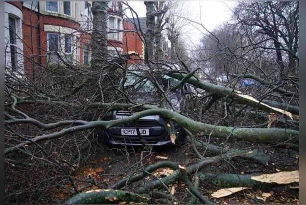 Sebuah kereta dihempap pokok tumbang akibat dilanda Ribut Darragh di Liverpool, England pada Sabtu. Foto AP