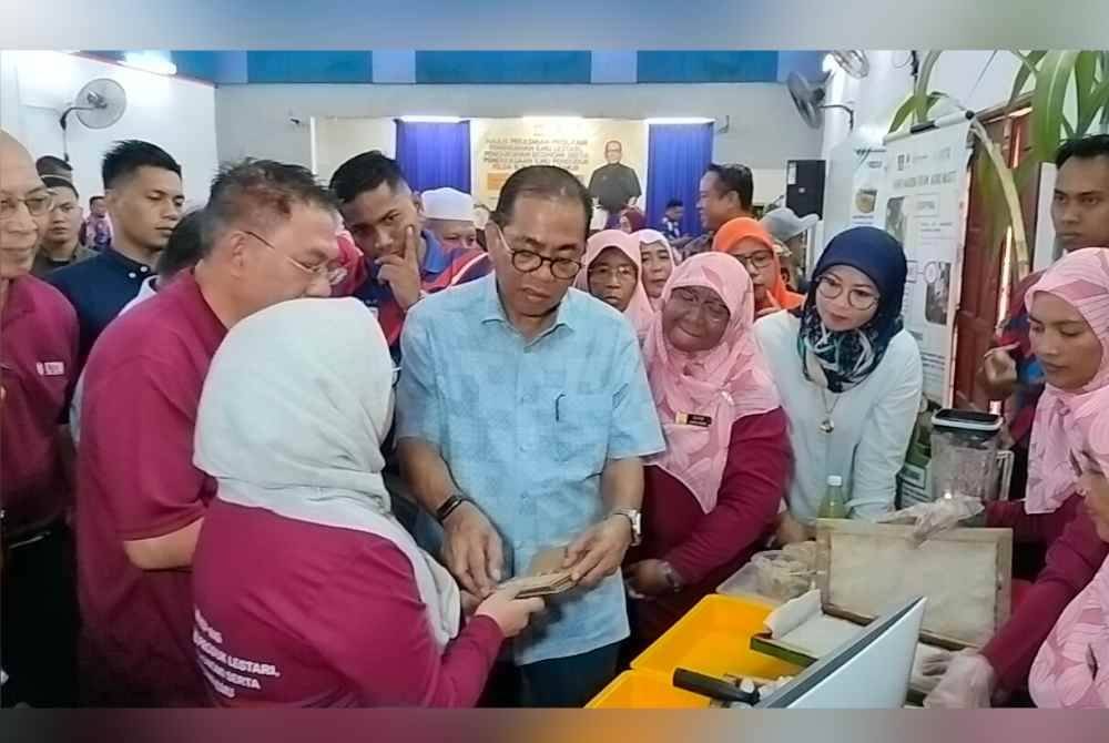 Mohamed Khaled ( tengah) melawat reruai pada Majlis Perasmian Program Pemindahan Ilmu Lestari, Pengukuhan Ekonomi dan Pemerkasaan Ilmu Penduduk di Felda Aping Timur, Kota Tinggi, pada Ahad.