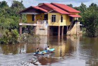 Penduduk setempat menggunakan bot untuk meninjau keadaan kediaman mereka yang masih digenangi banjir walaupun air mulai surut ketika tinjauan di Kampung Lachang, Rantau Panjang hari ini. Foto Bernama