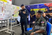 Ayob Khan (duduk) mendengar taklimat yang disampaikan oleh Mohd Yusoff semasa beliau turun padang meninjau situasi banjir di Kelantan pada Ahad. FOTO: SINAR HARIAN-HAZELEN LIANA KAMARUDIN