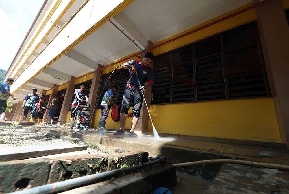 Sukarelawan terdiri daripada penuntut IPT, pelajar sekolah dan guru-guru bergotong royong membersihkan SMK Seri Gunong yang terjejas banjir, hari ini. Foto Bernama