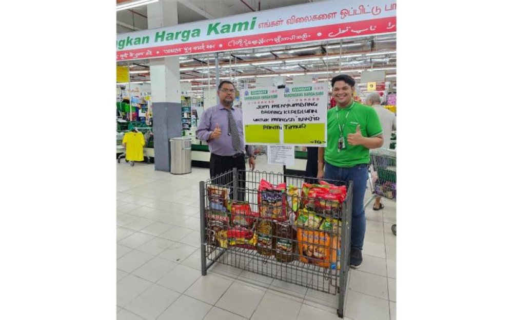 Pengurus Besar Econsave, Mas Imran Adam (kiri) menunjukkan ruangan khas di cawangan pasaraya berkenaan untuk para pelanggan menyalurkan bantuan barangan keperluan untuk disumbangkan kepada mangsa banjir di Pantai Timur.