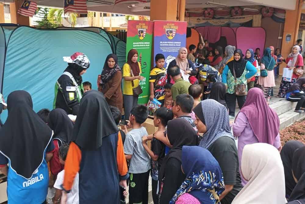 Sukarelawan dan anggota TH mengedarkan bantuan bekalan harian dan pek makanan kepada mangsa banjir.