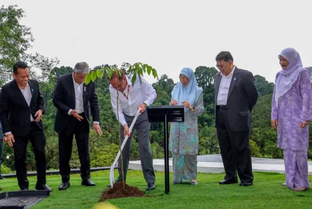 Anwar (empat dari kanan) menyempurnakan Majlis Penanaman Pokok ke-100 juta di bawah Kempen Penanaman 100 Juta Pokok 2021-2025 di Taman Herba Parlimen hari ini. Foto Bernama