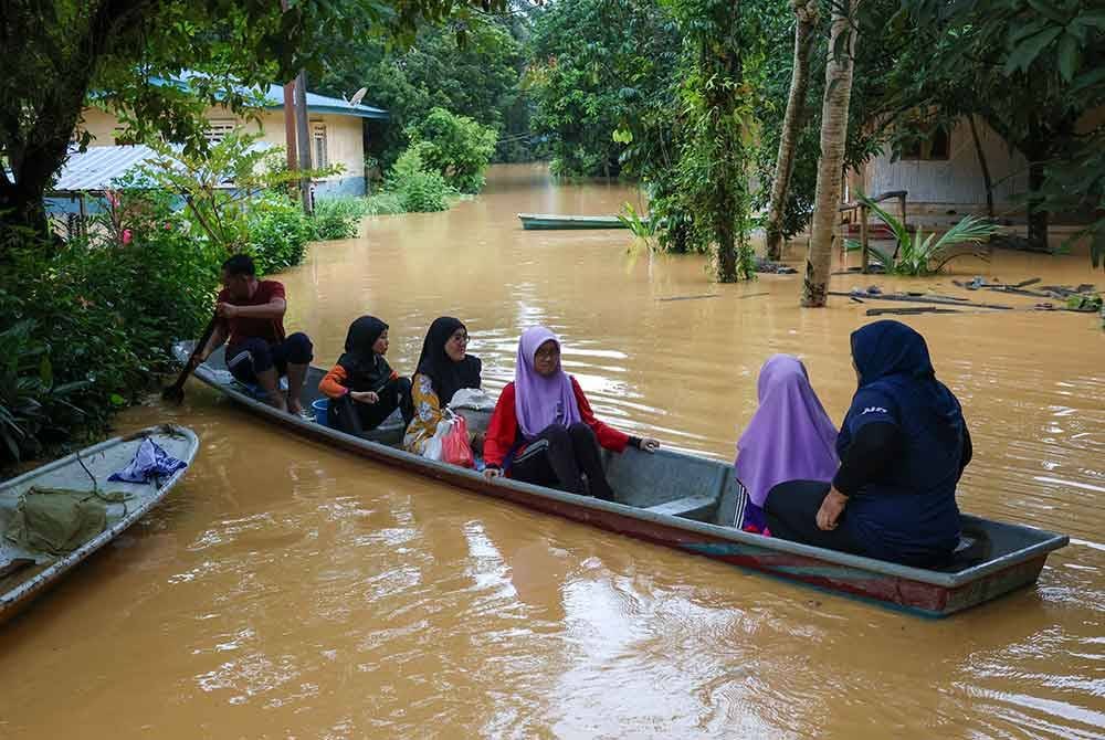 Penduduk di Gua Musang mengunakan bot untuk melakukan aktiviti harian selepas perkampungan mereka dinaiki air. Foto Bernama