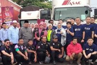 Aida Lim (berdiri, lima dari kanan) bersama sukarelawan IFE dan wakil kerajaan negeri selepas Majlis Penyerahan Sumbangan Banjir Kelantan