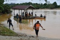 Penduduk sekitar masih menjalankan aktiviti harian seperti biasa walaupun air Sungai Kelantan di Jeti Pasir Kelang pada paras berjaga-jaga selepas hujan lebat sejak malam tadi ketika tinjauan hari ini. Foto Bernama