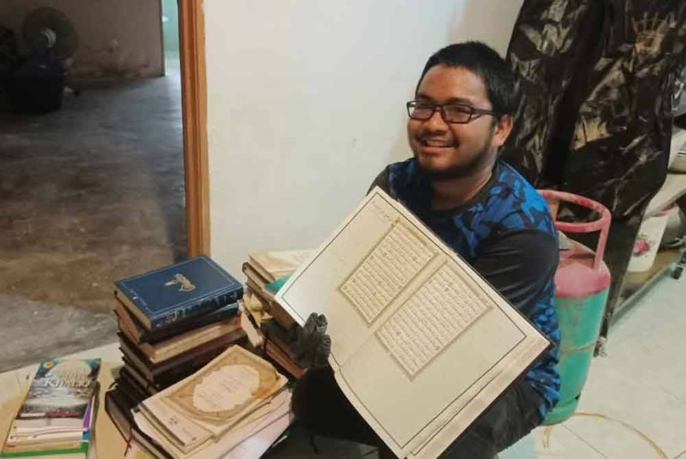 Nabil menunjukkan sebahagian al-Quran yang masih baik walaupun rumahnya di Taman Tabung Haji, Kepala Batas, dinaiki air pada minggu lepas.