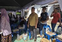 Kamarul (kiri) mengambil inisiatif menganjurkan Program Jualan Rahmah demi membantu penduduk setempat yang terkesan banjir baru-baru ini.