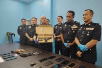 Ahmad Sukarno menunjukkan pistol yang dirampas susulan tangkapan kes menyamar polis, di Taman Usahawan Kepong, Kuala Lumpur baru-baru ini.