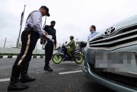 Anggota polis trafik melakukan pemeriksaan pada Operasi Saman Tertunggak Warga Asing 2024 di pintu masuk dan keluar Kompleks Imigresen, Kastam, Kuarantin dan Keselamatan (ICQS) Padang Besar hari ini. - Foto: Bernama