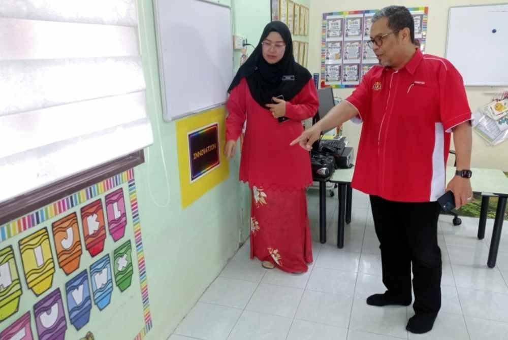 Mohd Hanafiah (kanan) melihat kesan banjir semasa melawat Tabika Kemas Alor Gunung pada Sabtu. Foto Bernama