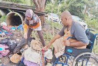 Zainal Abidin dan isteri memeriksa barangan jualan mereka yang tidak dapat diselamatkan dalam banjir gelombang kedua sejak Selasa lalu. Foto Bernama