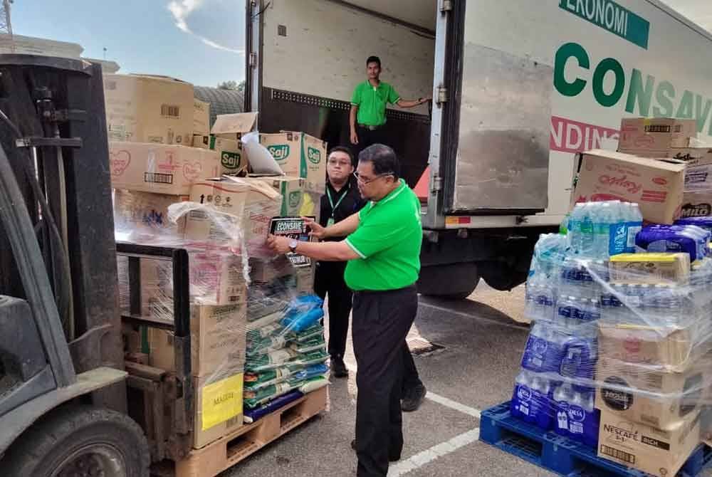 Mas Imran melihat barangan kering dan pakaian yang dihantar kepada mangsa banjir di pantai timur di Econsave Senai pada Sabtu.