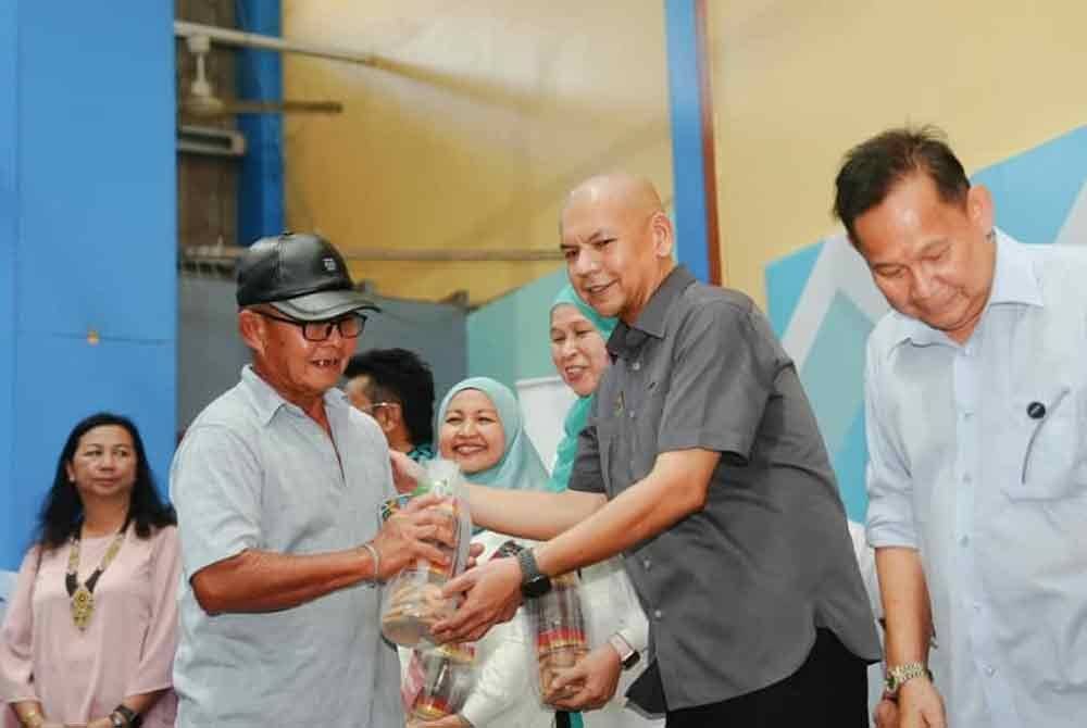 Armizan menyampaikan sumbangan kepada keluarga menerusi bantuan daripada Yayasan Petronas dalam program PJRM di Gereja Saint (St) Augustine, Kinarut, Papar.