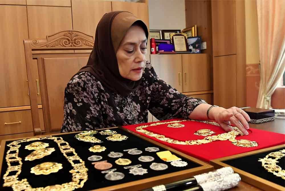 Putri Rafidah menunjukkan sebahagian pingat-pingat darjah kebesaran bersadurkan emas dan perak yang dihasilkan Mariwasa. Foto Bernama