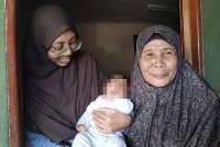 Nur Izzaty (kiri) bersama bayi dan ibunya, Fauziah semasa ditemui di Taman Seri Utama, Jitra pada Isnin.