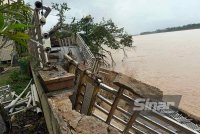 Laluan pejalan kaki di tebing Sungai Kelantan yang runtuh dan pokok tumbang pada Isnin.