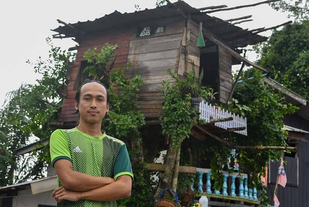 Mohd Nor Afiq menunjukkan pondok yang dibina atas pokok di hadapan rumahnya sebagai persiapan menghadapi musim tengkujuh yang belum berakhir di Kampung Kubang Tebakang. Foto Bernama