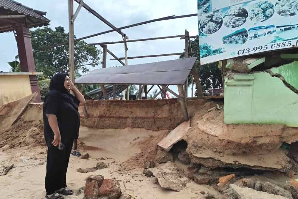 Azlieya menunjukkan gerainya yang musnah akibat fenomena air pasang besar dan hujan lebat baru-baru ini.