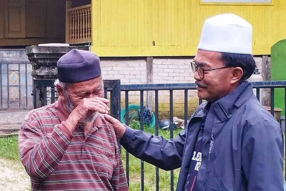 Mohd Zawawi (kanan) menenangkan Mamat (kiri) yang masih trauma dengan insiden berlaku awal pagi Rabu. FOTO: Facebook Cikgu Awi