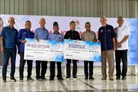 Mohamad (empat dari kanan) menyampaikan sumbangan kepada mangsa banjir semasa lawatan kerja di Dewan Terbuka PPK Bunga Raya, Tumpat pada Rabu. - Foto Sinar Harian