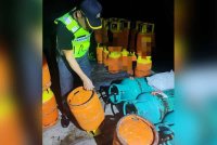 Anggota KPDN memeriksa tong LPG yang ditemukan dalam serbuan di sebuah premis di Jalan Alor Bukit, Kulai, Johor pada Isnin.